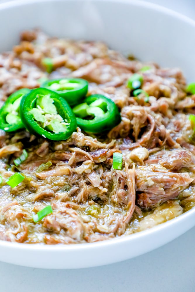 bowl of shredded pork with green chiles and jalapenos on it
