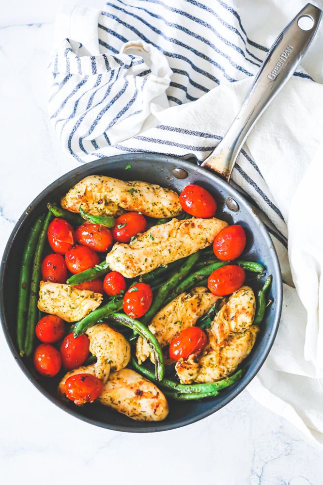 chicken, green beans, and tomatoes in a green pan