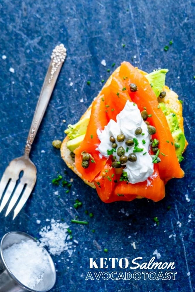 piece of bread with avocado, salmon, creamy, capers, and chives on it