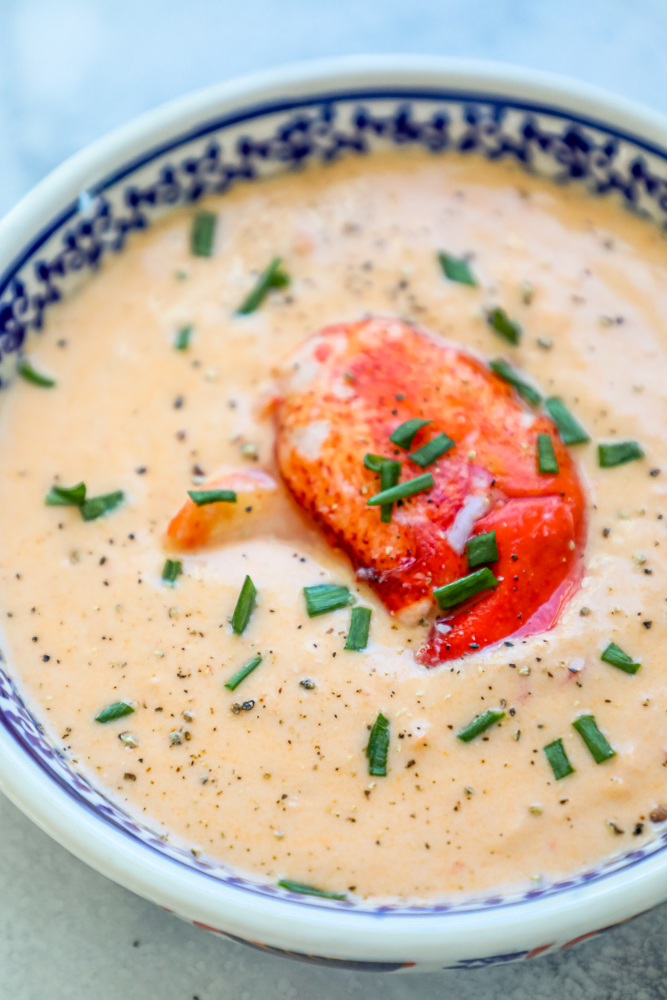 creamy soup with lobster and chives on it