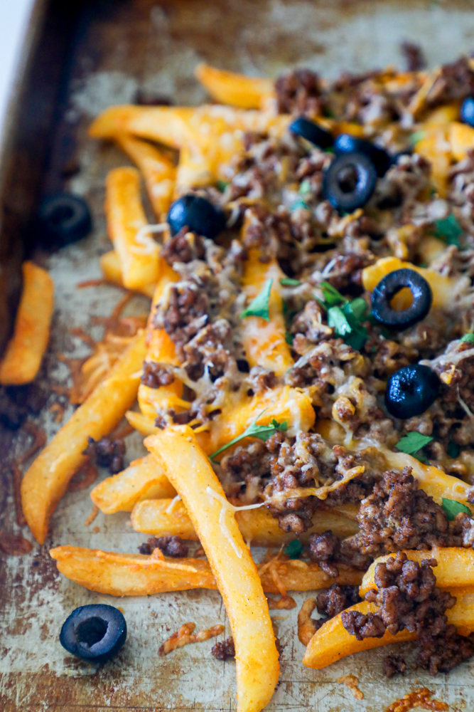 fries on a sheet pan with ground beef, cheese, and black olives