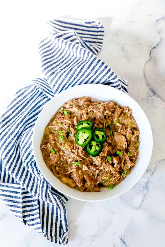 bowl of shredded pork with green chiles and jalapenos on it