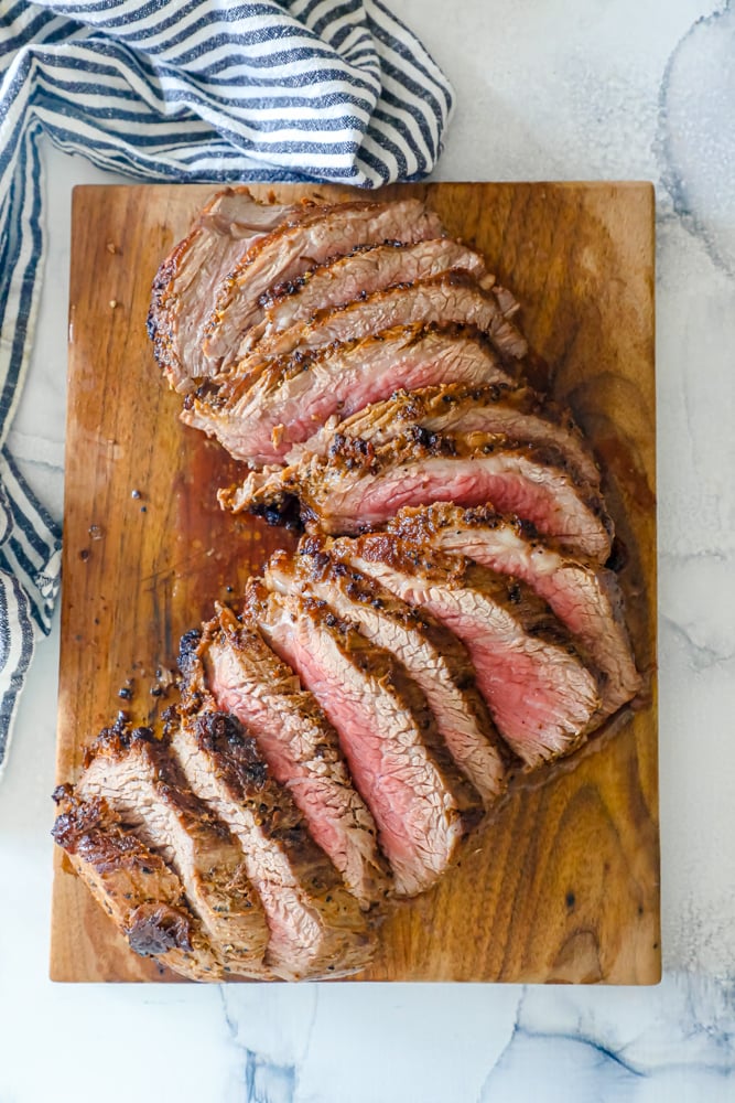 tri tip steak sliced on a board