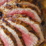 Close-up of several slices of medium-rare roast beef, featuring a browned crust and juicy pink center—perfect inspiration for your next Keto Tri Tip Steak or Best Broiled Tri Tip Steak using your favorite ninja foodi steak recipe.
