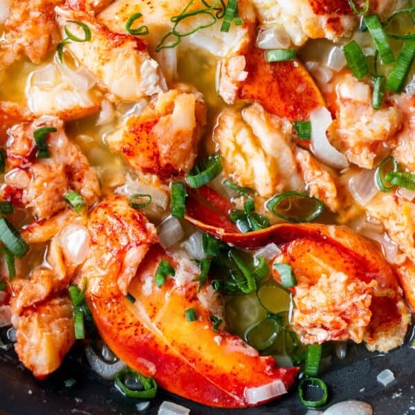 Chunks of cooked lobster meat in a buttery sauce, garnished with chopped green onions—a perfect Easy Garlic Butter Lobster Skillet for any occasion.