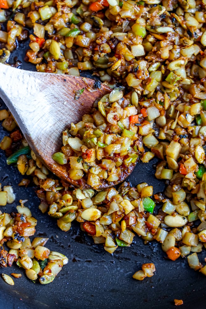 fried rice with onion, cabbage, and nuts with spoon in it