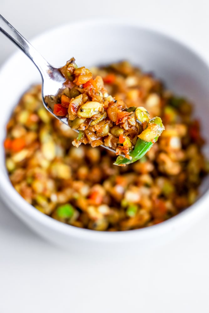 fried rice with onion, cabbage, and nuts on a fork