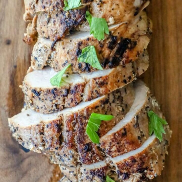 Grilled chicken slice on a cutting board.