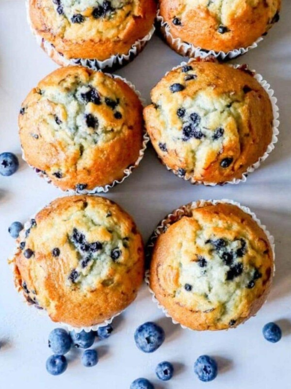 picture of blueberry muffins on a table next to blueberries