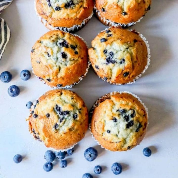 picture of blueberry muffins on a table next to blueberries