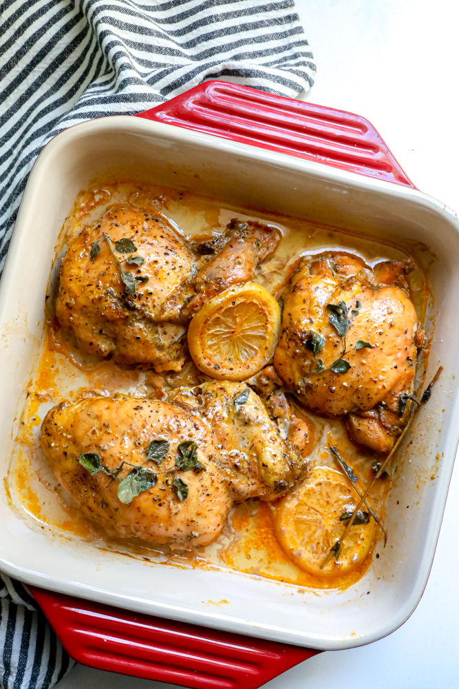 3 chicken thighs in a baking dish with oregano and lemon