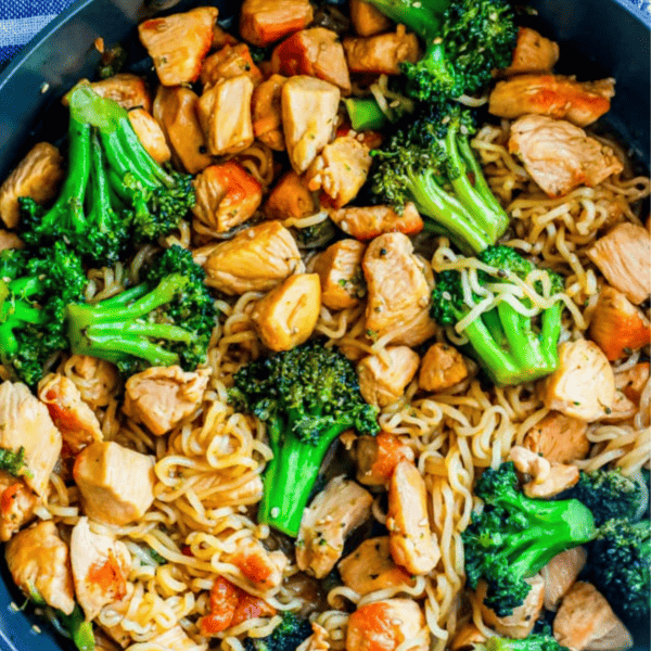 Chicken and broccoli stir fry in a skillet with teriyaki noodles.