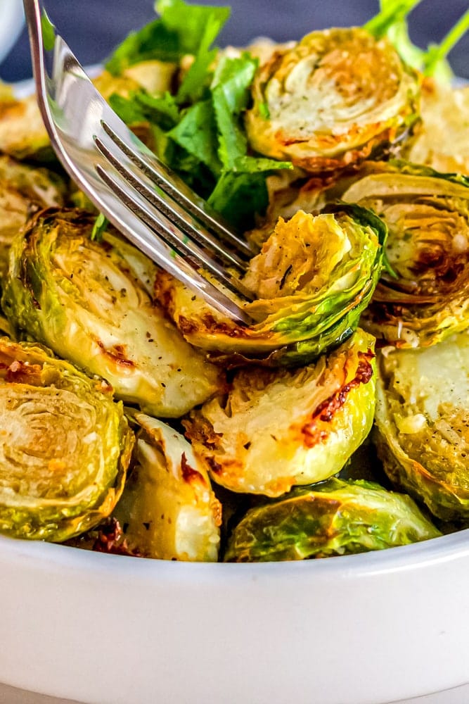 picture of a fork going into a bowl of air fried brussels sprouts