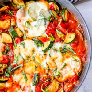 A skillet filled with eggs, tomatoes and zucchini cooked in a Zucchini Marinara skillet.
