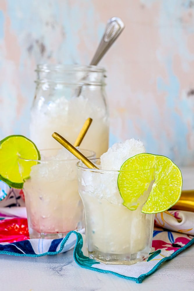 picture of two glasses with frozen gin and tonic in it and a jar of frozen gin and tonic in the background