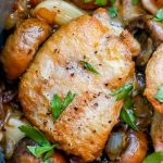 Chicken with mushrooms and parsley in a skillet.