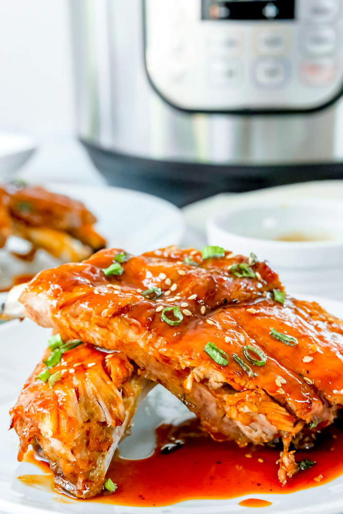 Instant pot sticky ribs and sauce on white platter picture
