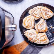 A plate of instant pot cinnamon rolls on a table.