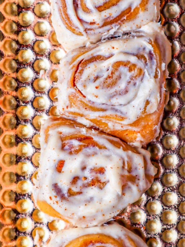 Cinnamon rolls with icing baked on a sheet.
