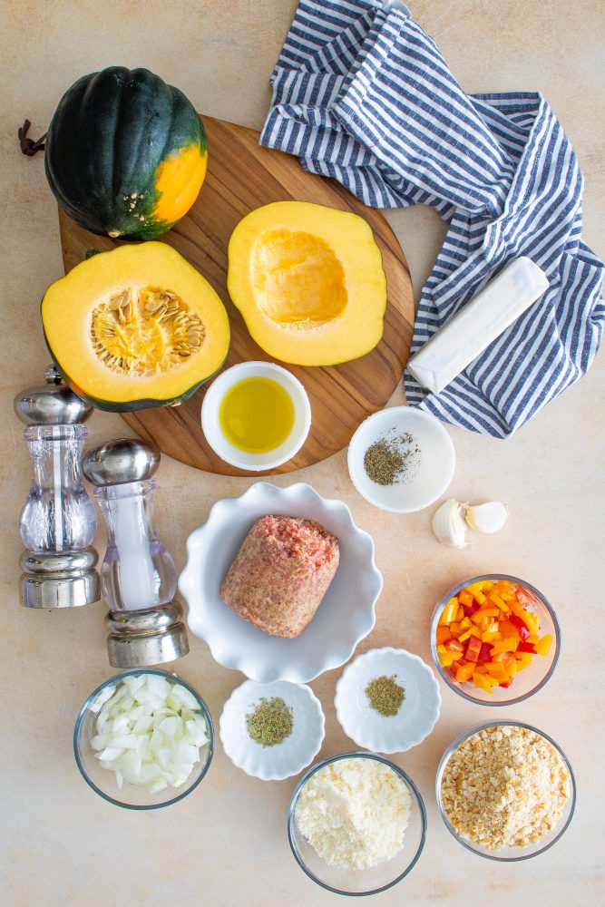 Close-up of a recipe for sausage-stuffed butternut squash on a wooden board.