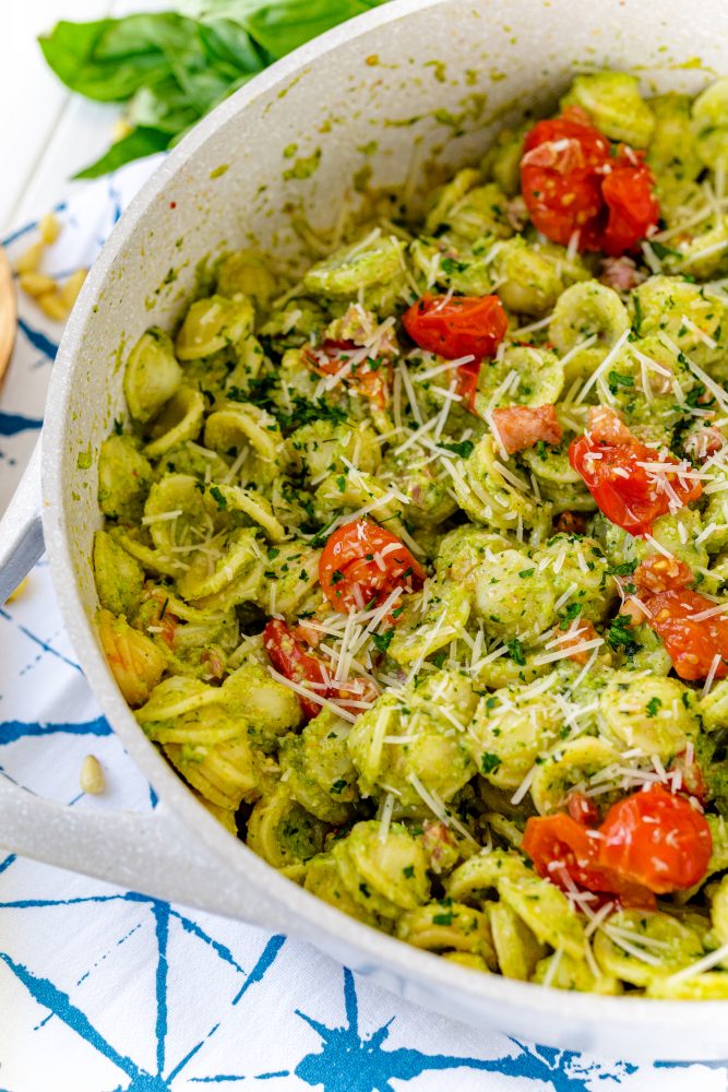 pasta with broccoli pesto over it, tomatoes, and parmesan