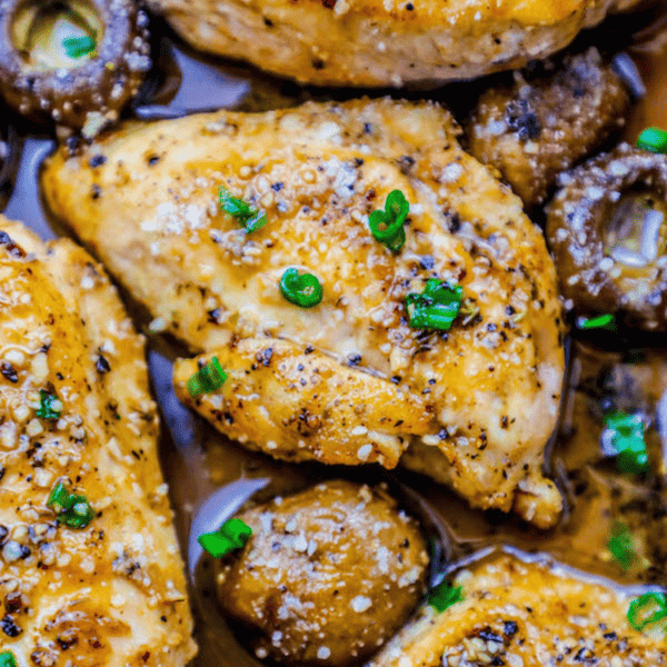 Creamy garlic Parmesan chicken thighs with mushrooms topped with herbs.
