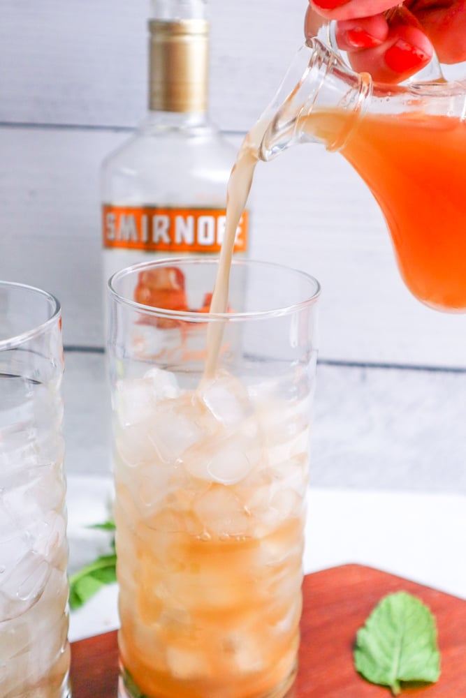 A person mixing an apple mojito cocktail.