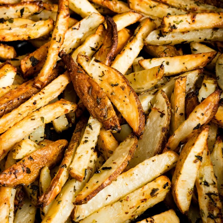 French fries cooked in an air fryer with lemon and garlic, served crispy from a skillet.