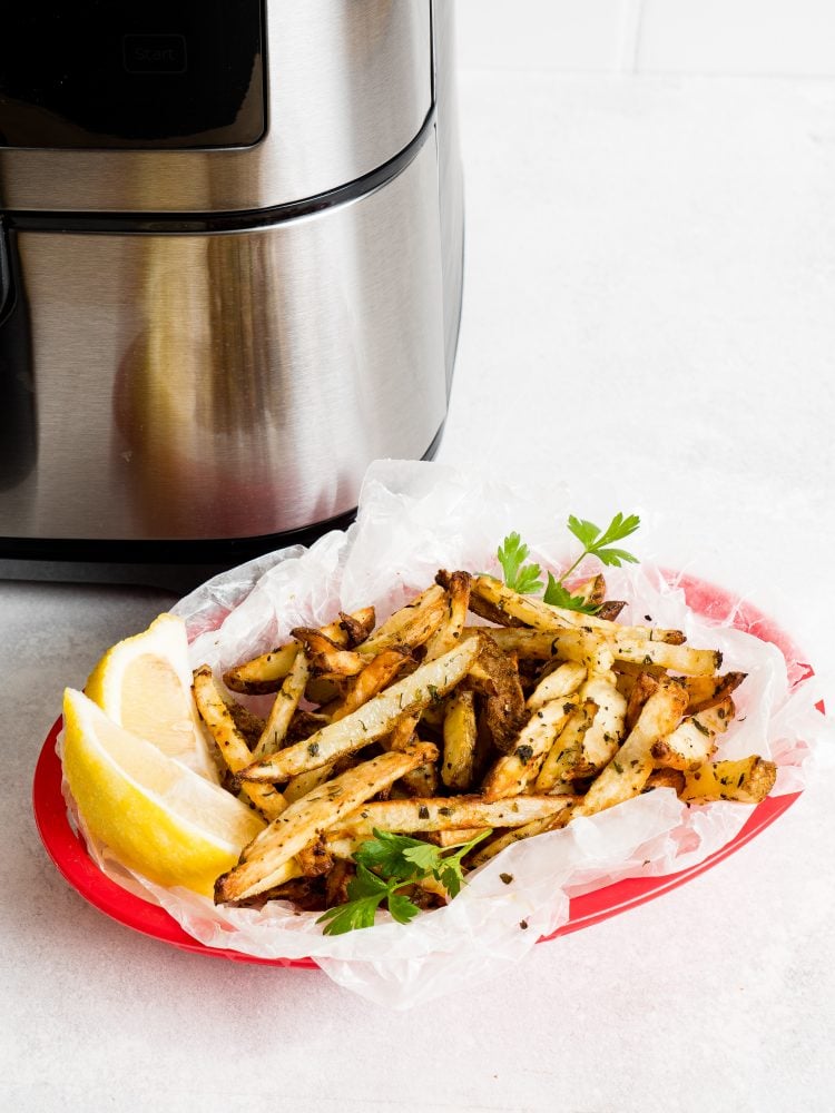 picture of french fries in a basket in front of an air fryer