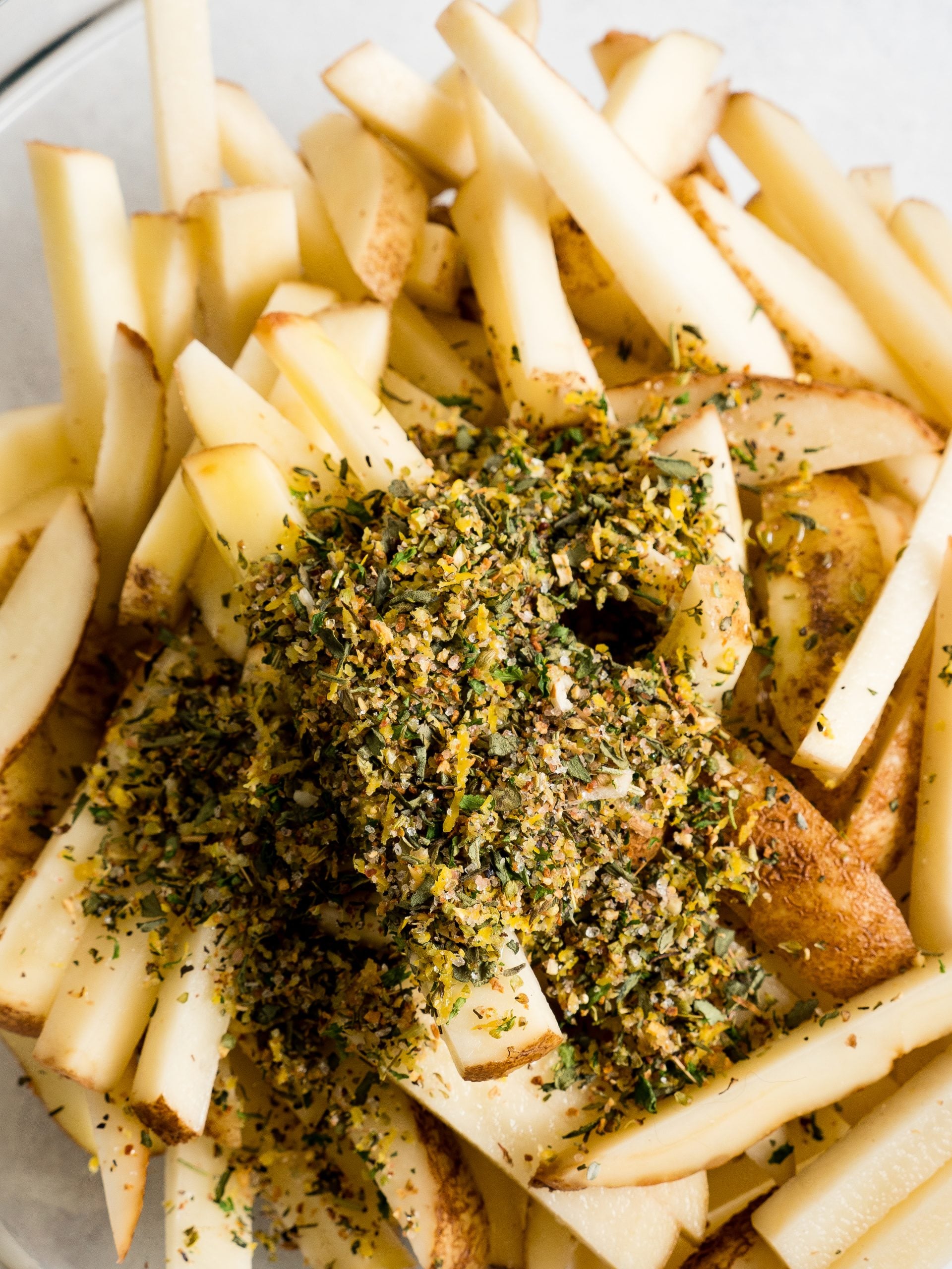 picture of seasoning being dumped on top of french fries