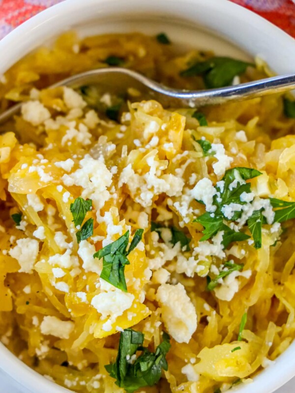 A bowl of roasted green chile spaghetti squash with feta cheese and parsley.