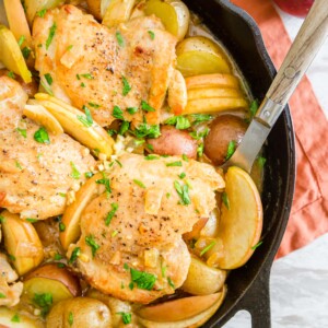 Chicken and potatoes cooked in a cast iron skillet.