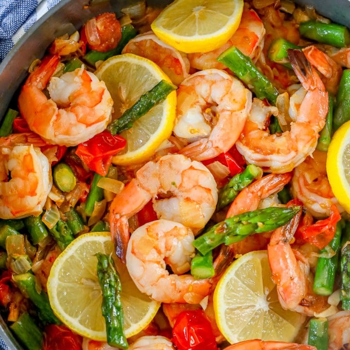 Shrimp and vegetable paella cooked in a skillet with asparagus.