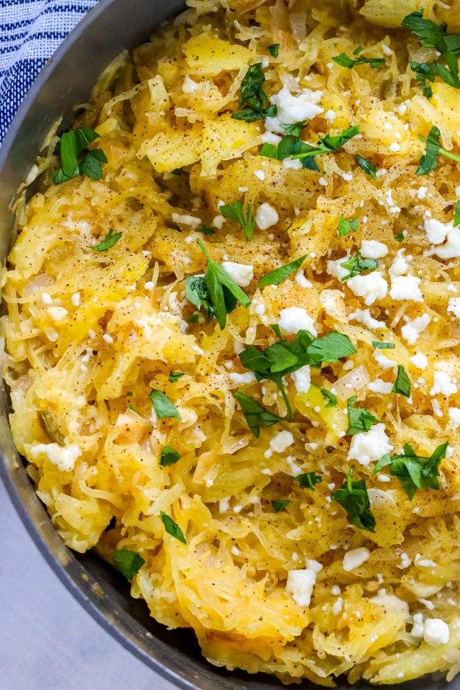 picture of spaghetti squash with green chile sauce and cheese in a skillet