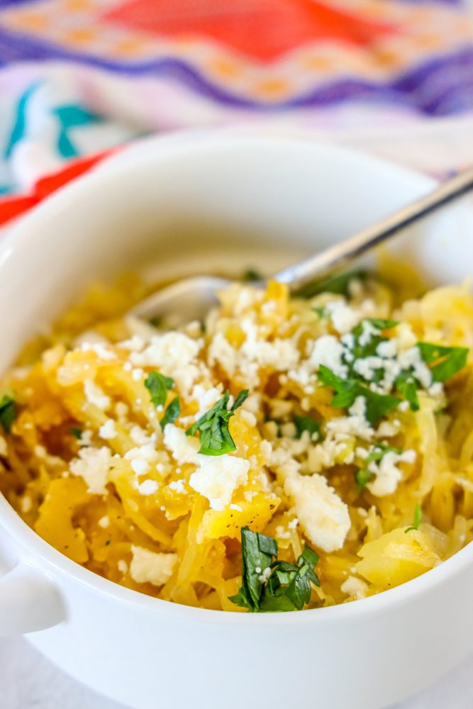 picture of spaghetti squash with green chile sauce and cheese in a white bowl 