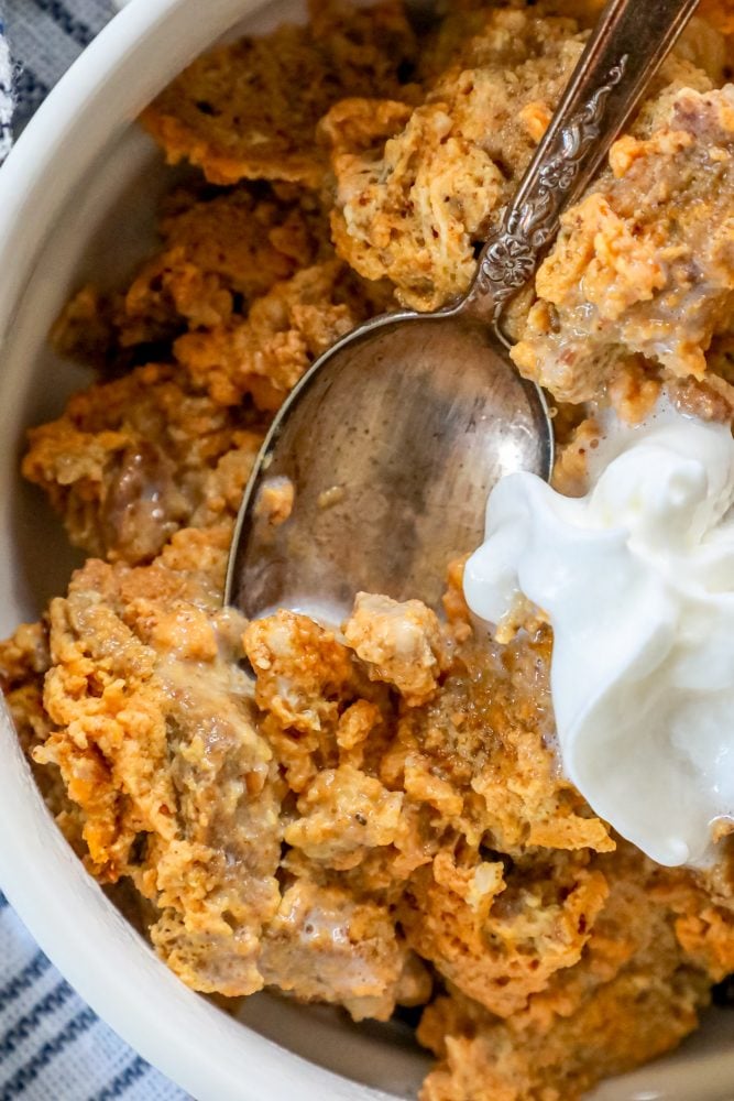 picture of keto bread pudding with whipped cream on a spoon 