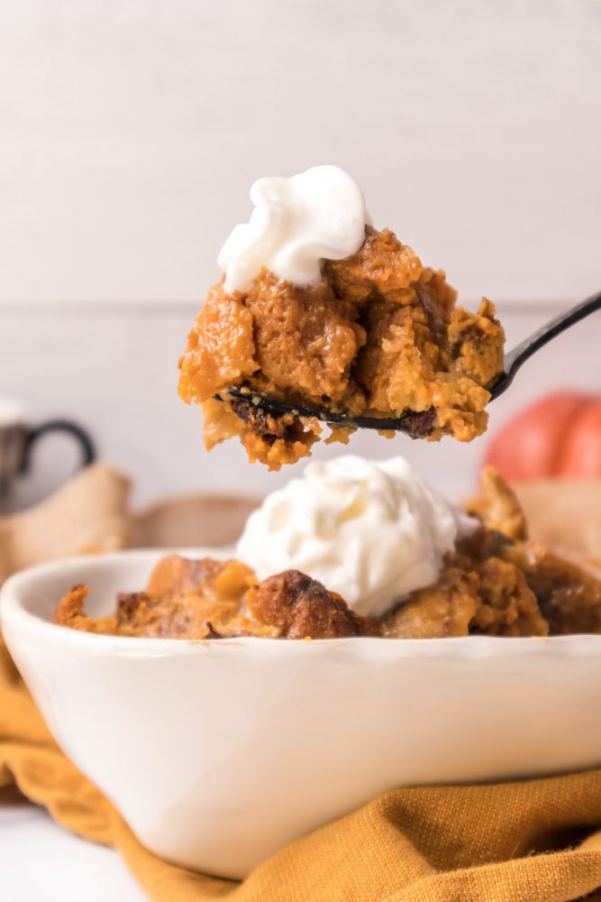 picture of pumpkin bread pudding with whipped cream on a fork 