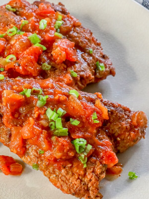 A plate of chicken breasts with tomato sauce.