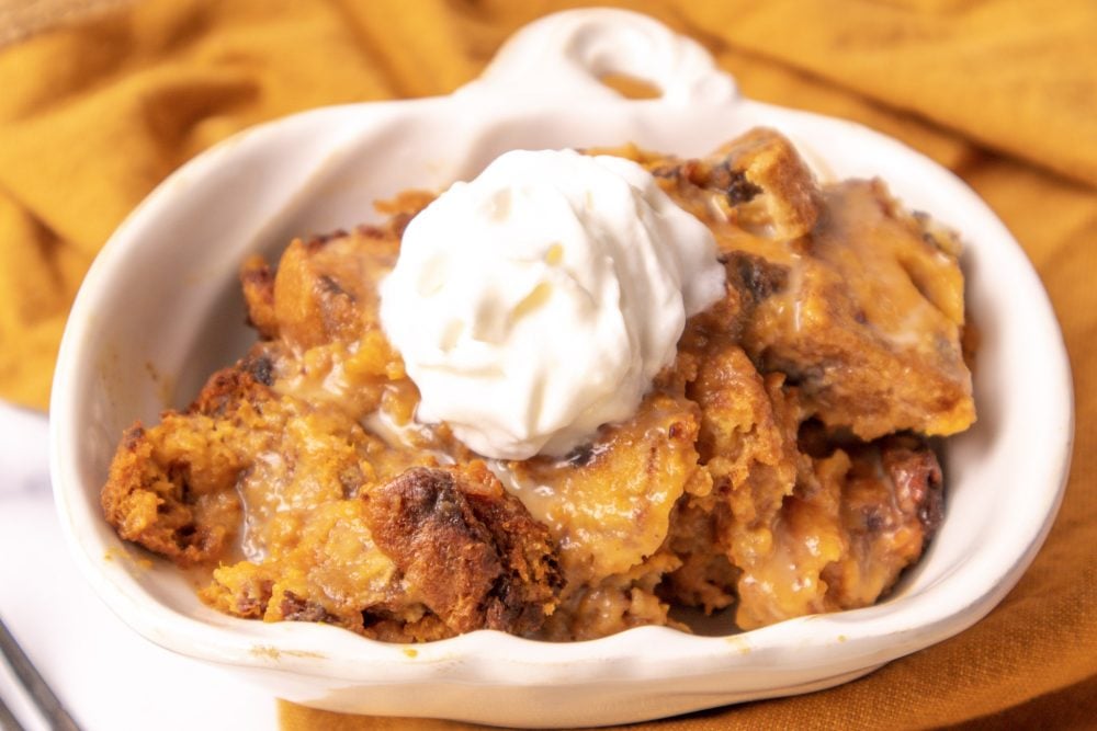 picture of pumpkin bread pudding with whipped cream on a fork 