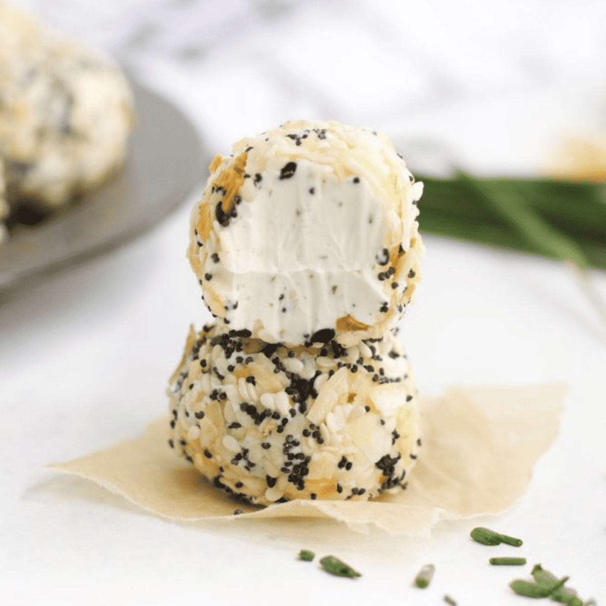 Two cheese balls stacked on top of each other resembling an everything bagel fat bomb.