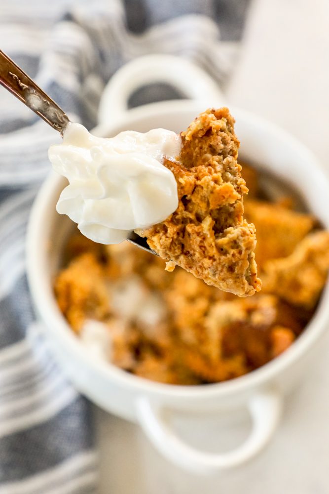 picture of keto bread pudding with whipped cream on a spoon 