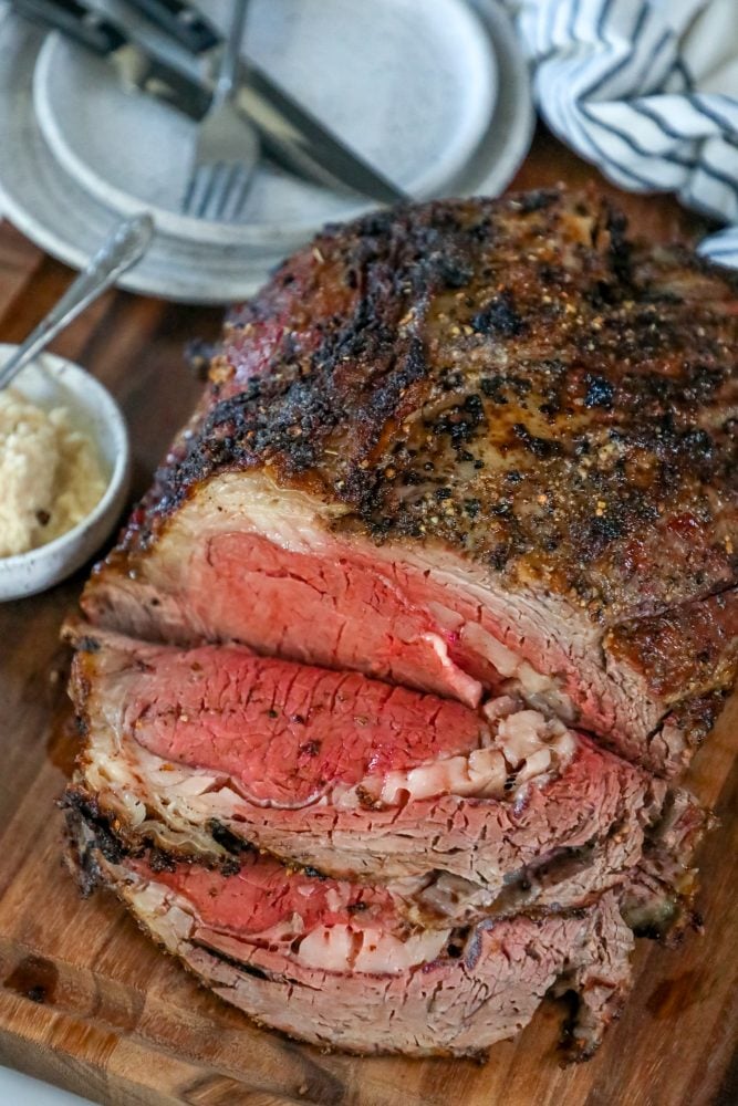 roasted prime rib sliced on a wood cutting board