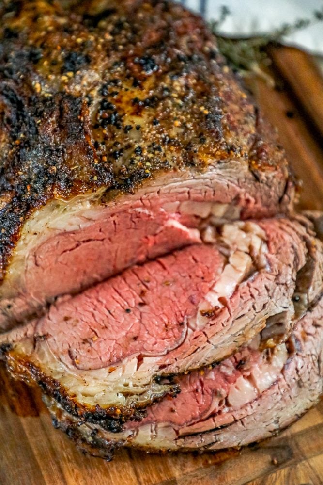 ribeye roast on a wood cutting board next to bowl of horseradish 