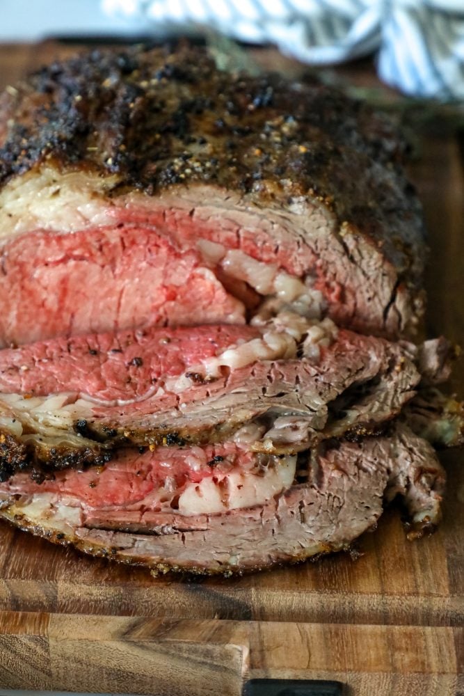 picture of ribeye roast on a wood cutting board next to bowl of horseradish 