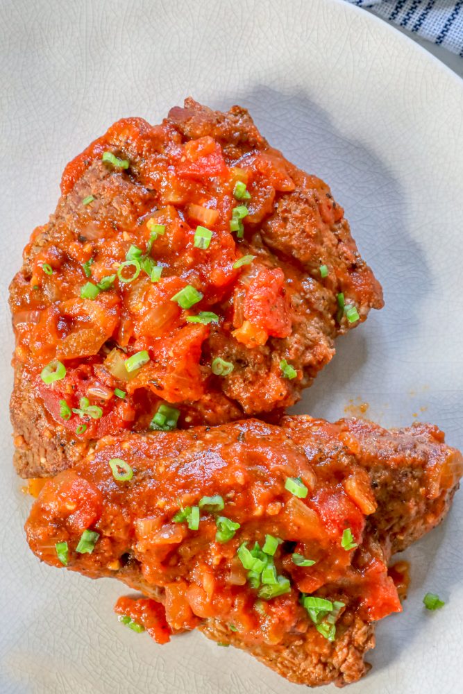 steak with outer coating and tomato sauce on top