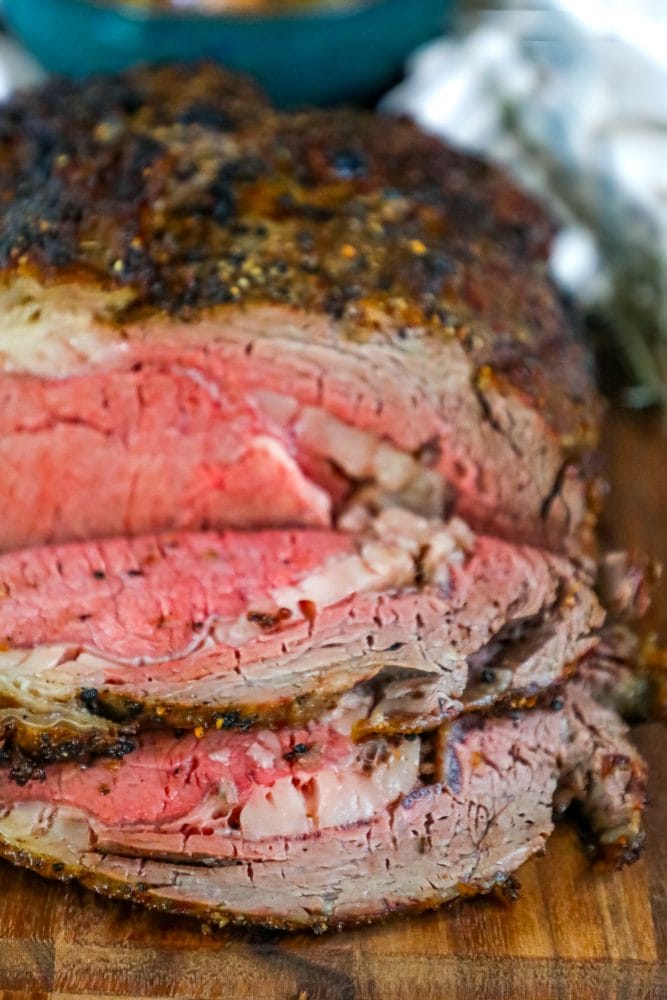 roasted prime rib sliced on a wood cutting board