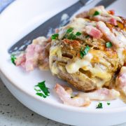 Keywords: ham and cheese

Modified description: A bowl filled with creamy hasselback potatoes layered with cheddar and bacon.