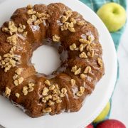 An apple spice bundt cake adorned with nuts.