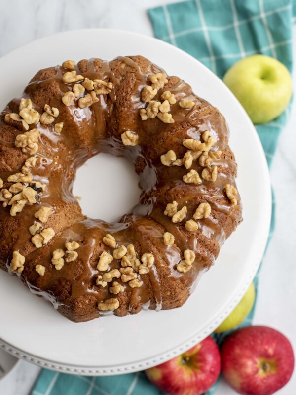 An apple spice bundt cake adorned with nuts.