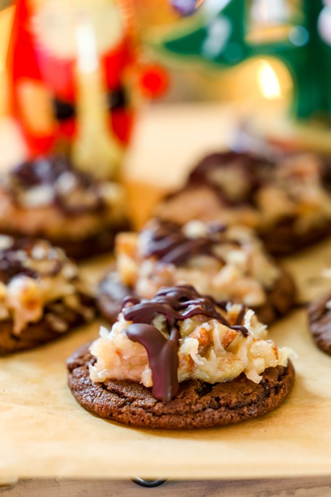 chocolate cookies covered in coconut and nut mixture and a drizzle of chocolate